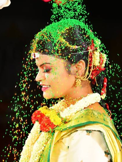 A joyful moment from a Muhurtham ceremony. The bride's profile shows her elegant hairstyle and makeup that holds up beautifully, even during the most active parts of the wedding rituals.