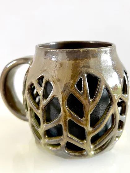 This is one of my favorite designs, the double-walled leaf mug. The outer wall is intricately carved with a leaf pattern, making it light to hold and beautiful to look at, while the solid inner wall keeps your drink warm.