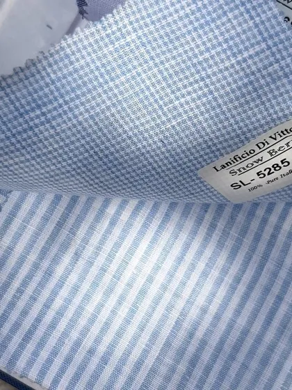A swatch of 100% pure Italian linen in a classic blue stripe and check pattern from Lanificio Di Vittorio.