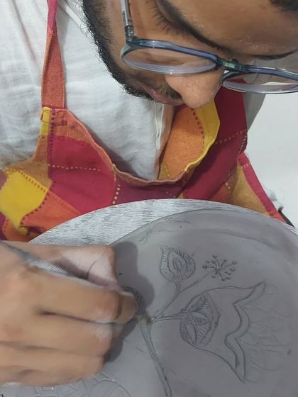 The level of detail and creativity that comes from first-time students always amazes me. This student is carefully etching a beautiful floral design onto his hand-built plate. It's a process that requires patience, and he did a wonderful job.