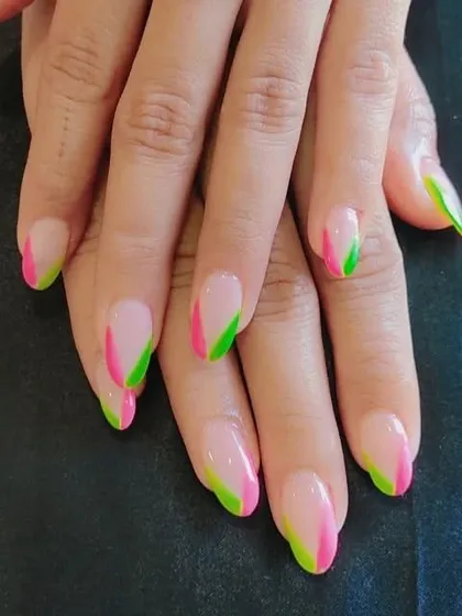 A vibrant and unique French manicure using dual-color diagonal tips in neon pink and green. This design is for anyone looking to make a bold and colorful statement.