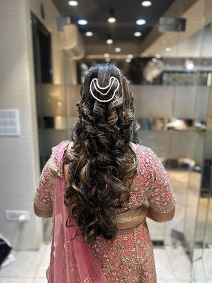 A back view of the same hairstyle, showcasing the full length and volume of the curls.