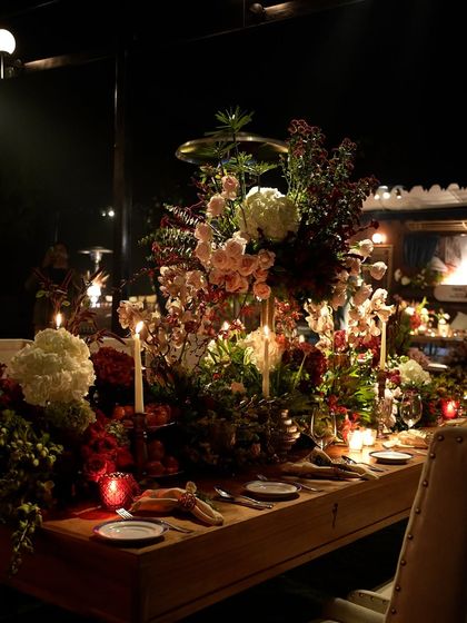 A full view of the long dining table, showcasing the layered composition of florals, candles, and elegant place settings.