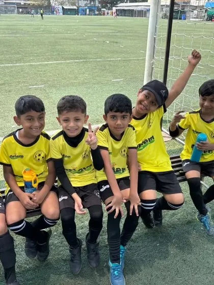 Our U-7 players relaxing on the bench, all smiles after a good game. The friendships made on the field are just as important as the wins.
