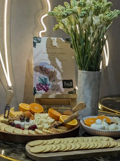 The complete wine and cheese setup at Trims & Tones, featuring a charcuterie board, fresh burrata, and crackers, all elegantly presented with a custom menu.
