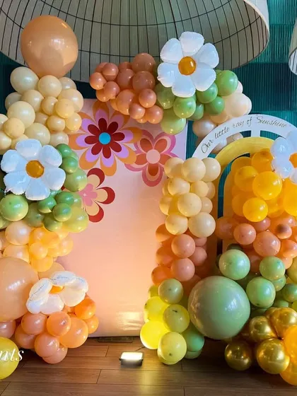 For a fun and groovy celebration, we designed this retro-inspired balloon backdrop. The arrangement features a unique color palette of orange, yellow, and green, with cheerful daisy accents for a bright and happy vibe.