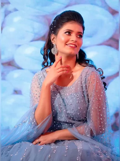 A close-up of this enchanting blue gown. The delicate beading and soft curls create a romantic and dreamy look for an engagement or reception.
