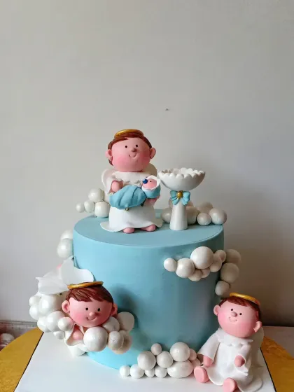 An angelic baptism cake in soft blue. This design features several cherubic angels sitting amongst fluffy fondant clouds, with one angel holding the baby. It’s a heavenly cake to celebrate a new beginning in faith.