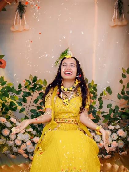 The sheer delight of a Haldi ceremony, with flower petals showering a laughing bride. We love capturing the fun and vibrant energy of pre-wedding festivities.
