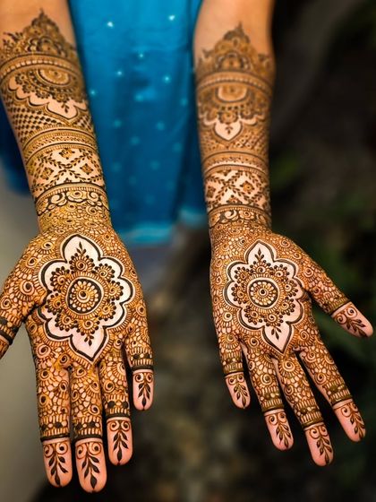 A beautiful mandala design on the palm, using negative space to make the central flower pop.