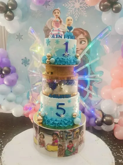 Another view of the five-tiered Frozen cake, highlighting the photo-customized bottom tier and the impressive height of the creation.