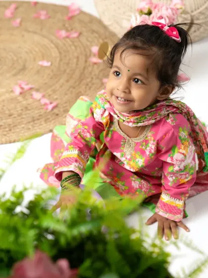 A beautiful candid shot of the little girl, looking up with a curious and happy expression during her family session.