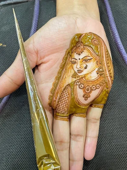 A close-up of a bride's portrait on the fingers, showing the three-dimensional effect I create with my natural henna paste. The thick application ensures a deep, rich stain.