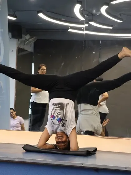 An impressive headstand (Sirsasana) variation, demonstrating the advanced skills and flexibility our members develop through consistent practice.