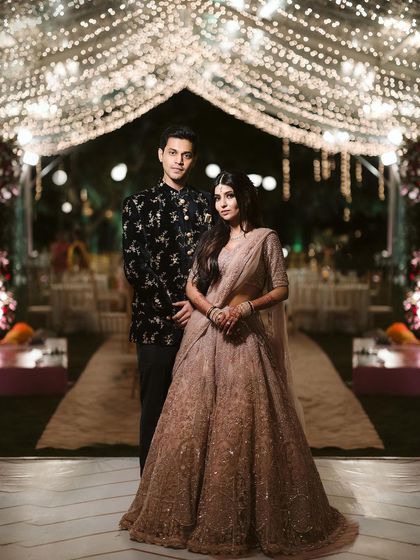 A beautiful couple poses under a canopy of fairy lights at their reception. I love creating these magical, starlit walkways that make for unforgettable photos and an even more memorable evening.