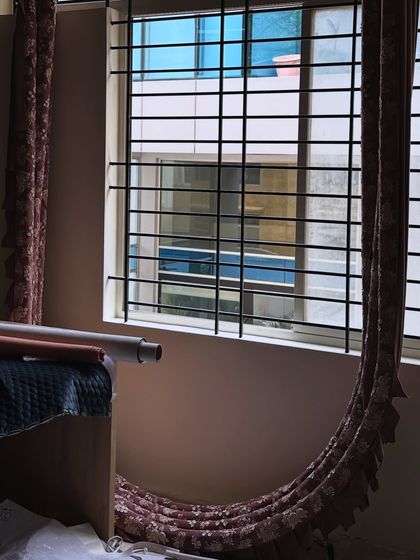 The process of design often involves waiting for the perfect moment. Here, a roll of custom embroidered fabric for the arches sits patiently by the window, its intricate details catching the light before its final installation.