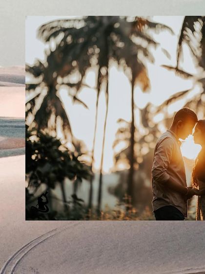 A romantic silhouette of a couple against the golden light of sunset, framed by palm trees.