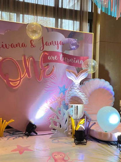 For Jivana and Janya's first birthday, we created another enchanting under-the-sea world, featuring marquee letters, iridescent backdrops, and a soft play area for the tiniest guests.
