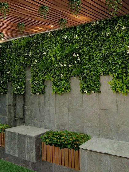 This vertical garden design combines a lush green wall with a modern stone base. The varying lengths of the green panels create a natural, cascading effect, perfect for adding a touch of elegance to any outdoor or indoor space.