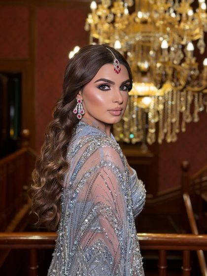 A dramatic shot showcasing the entire look. The chandelier in the background adds to the opulent and glamorous feel of her cocktail night.