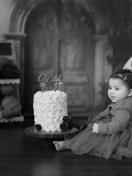 Another classic black and white image from the first birthday session. This captures a quiet, contemplative moment before the cake smash.
