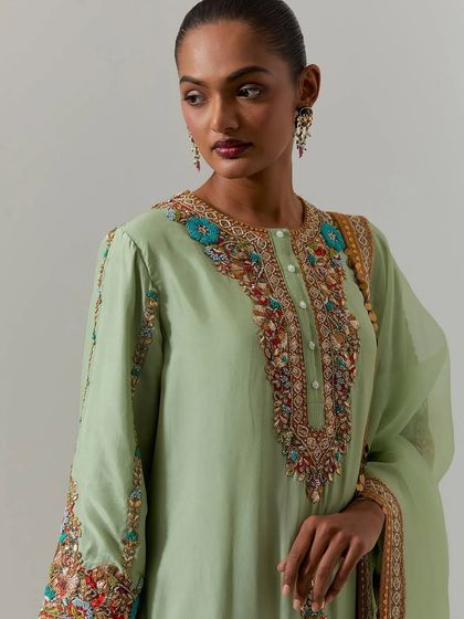 A portrait shot highlighting the detailed embroidery around the neckline of the elegant pista green kurta.