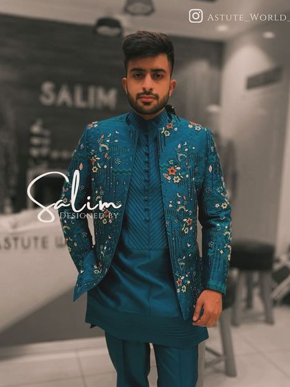 A client in a teal blue Indo-Western set. The jacket features delicate floral embroidery, adding a touch of softness to the structured silhouette.