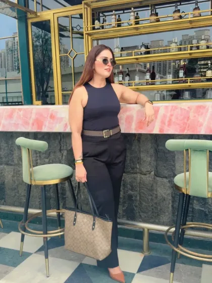 A casual take on power dressing, perfect for a business lunch or a creative meeting. The sleeveless top paired with formal trousers and a statement belt creates a look that's both relaxed and put-together.
