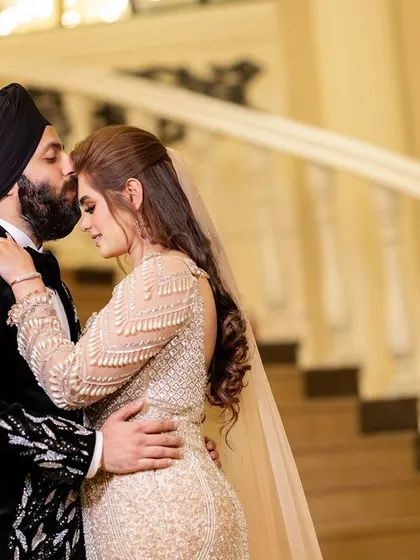 A tender embrace between the couple. The groom's kiss on the bride's forehead is a classic romantic gesture that we capture with elegance.
