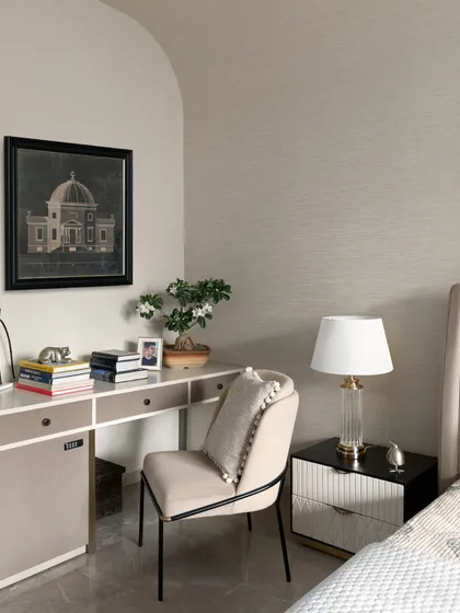 A quiet study corner within the master bedroom of the Juneja Residence. The space is defined by a gracefully arched wall and features a natural woven wall covering, creating a bright and calming spot for work or reflection.
