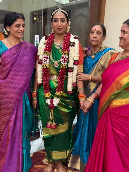 Surrounded by the love of family, the bride stands tall and proud in her perfectly draped green Madisar saree.