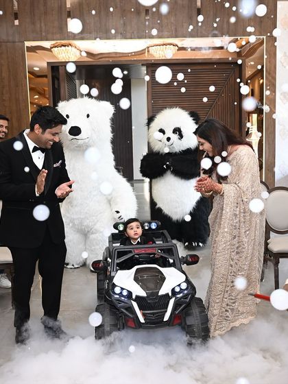 Making a grand entrance to his first birthday party. This little one is the center of attention in his custom tuxedo, arriving in style and ready to celebrate with his family.