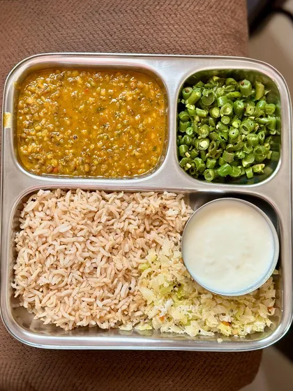 A balanced meal of brown rice, moong dal, sautéed cabbage, green beans, and curd. This is a simple, everyday meal that is both healthy and satisfying.