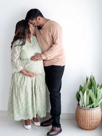 An intimate pose from a couple's maternity shoot, showing the connection and support between partners.