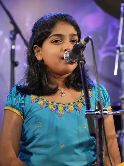A close up of a young student singing with devotion during the Shiva Bhajan segment of our annual show.