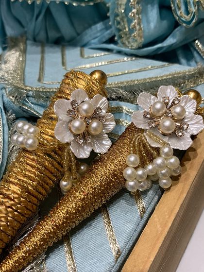 This elegant trousseau packaging was designed for a Teej ceremony. The pearl and crystal flower embellishments on the golden cones add a touch of bridal charm and sophistication.