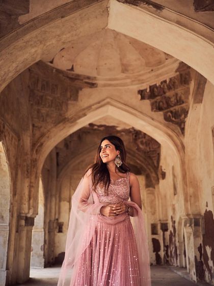 A joyful, candid-style shot within a historic location. The model's smile and the grandeur of the setting create a beautiful contrast, telling a story of modern celebration in a timeless place.