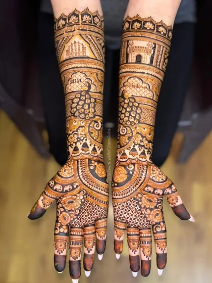 A tribute to the couple's heritage, this bridal design features Jaipur's Hawa Mahal on one arm and Hyderabad's Charminar on the other. Your love story, illustrated with intricate henna details.