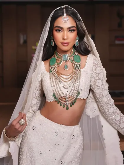 The full look. A modern bride in a stunning white lehenga, with makeup that is both elegant and timeless.