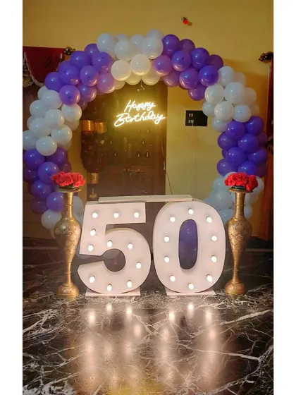 Celebrate milestone anniversaries and birthdays in style. We provide large marquee numbers, like this "50", that create a fantastic focal point for photos, complemented by a classic purple and white balloon arch and a custom neon sign.