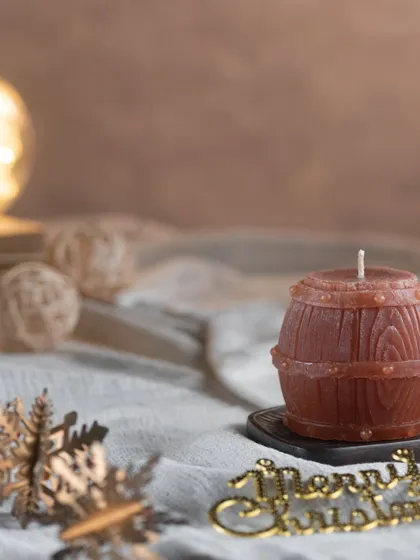 This candle is shaped like a rustic wooden barrel. It's a great decorative piece for a bar or a man cave.