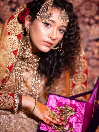 This image highlights the rich colors and textures of traditional bridal attire and how the makeup enhances the overall look.