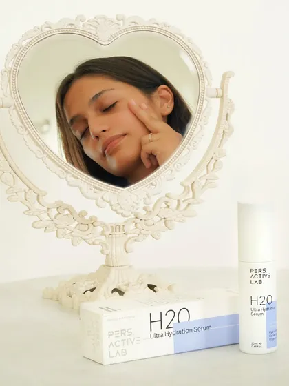 This shot uses a heart-shaped mirror to frame the model's face as she applies the serum, creating a narrative of self-love and care. It connects the product to a personal and gentle skincare ritual.