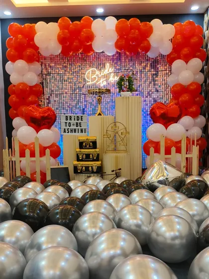 Perfect for a bride-to-be party, this red, white, and silver balloon decoration creates a fun and festive vibe. The setup includes a full balloon frame, a "Bride to be" neon sign, and plenty of floor balloons for a complete party look.
