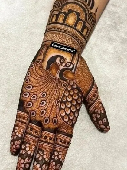 A single-hand design showcasing a magnificent peacock, its feathers flowing down the fingers. The arm features a classic palace dome.