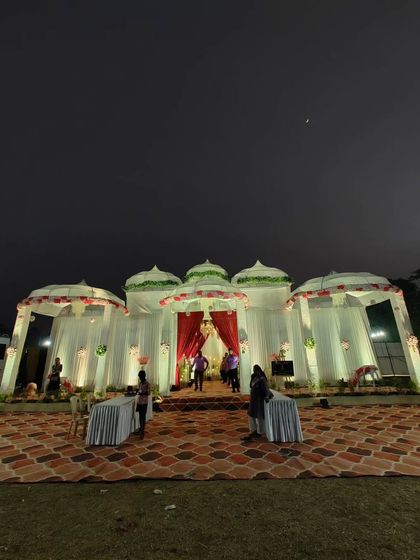 This night view shows how I use lighting to transform a space. The white dome-topped structures, inspired by traditional Indian architecture, are illuminated to create a magical and inviting atmosphere for an evening event.