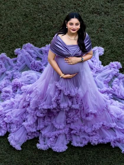 An aerial view shows the full splendor of the lavender gown's ruffled train spread out on the grass. This is a popular shot that truly highlights the artistry of the dress.