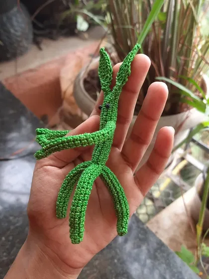 Holding the Pickett amigurumi shows his delicate, stick-like form. It was a fun challenge to crochet something so slender and detailed.