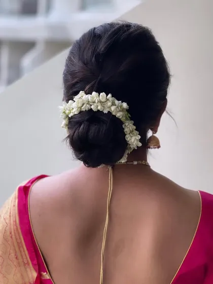 A clean and classic South Indian bun, wrapped neatly with fresh mogra flowers.