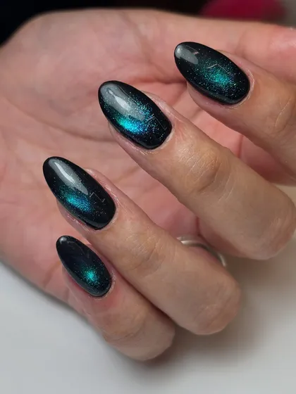 A palette reminiscent of the night sky. This galaxy-like effect is created with a deep blue and green magnetic cat-eye polish over a black base.